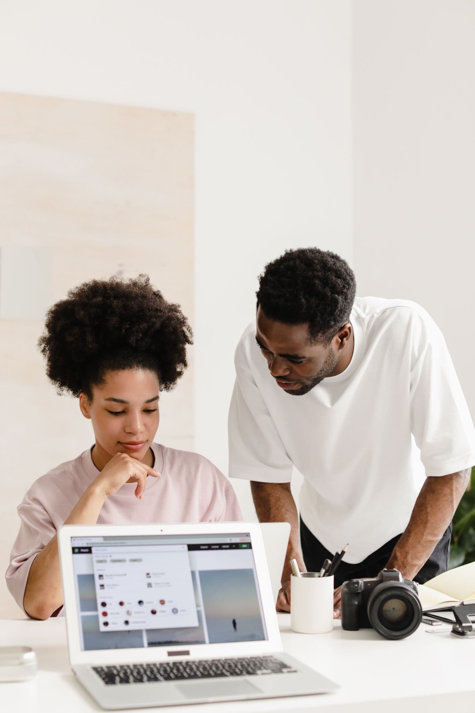 Two colleagues reviewing work together on a laptop